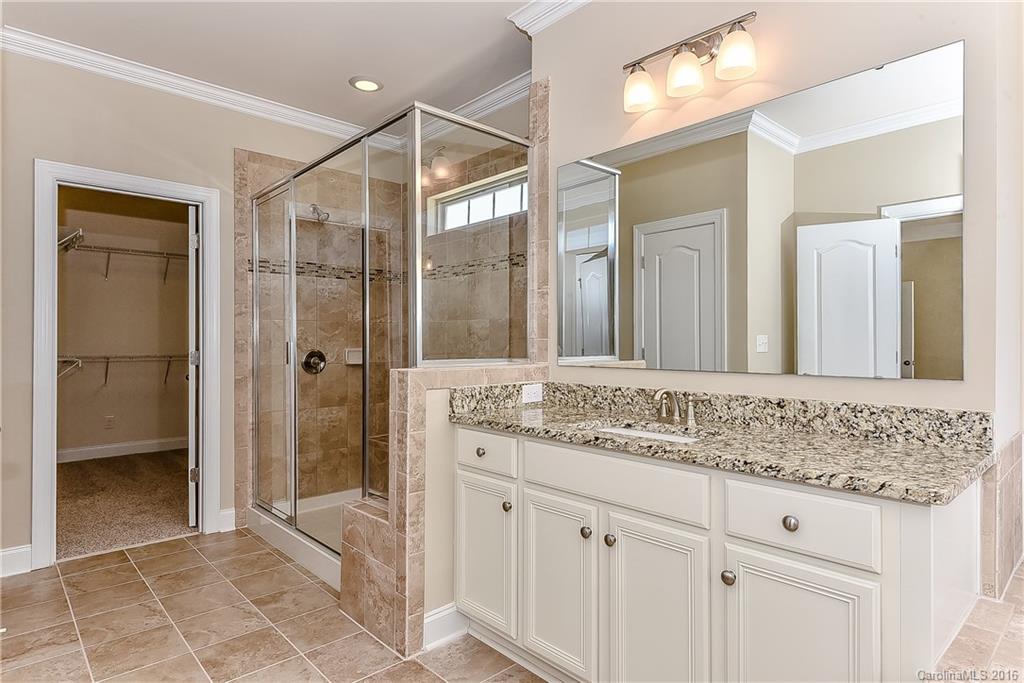 604 Brookhaven Drive, Unit HKC 95 Fort Mill, SC 29708 - Photo 15 of 24 a bathroom with a granite countertop sink a mirror and a shower