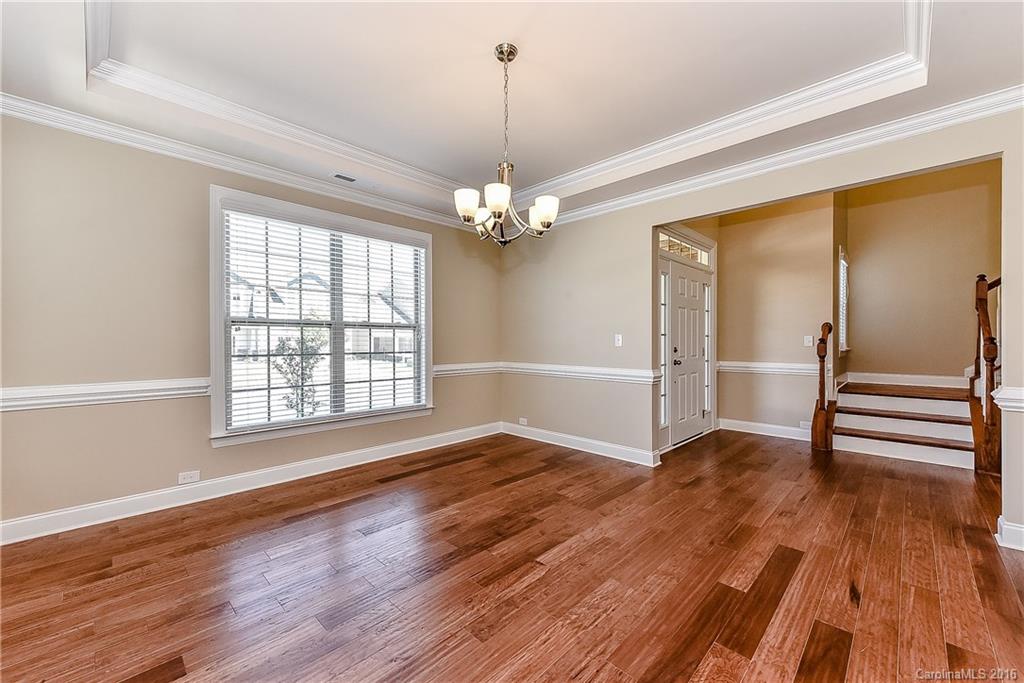 604 Brookhaven Drive, Unit HKC 95 Fort Mill, SC 29708 - Photo 6 of 24 an empty room with wooden floor chandelier and windows