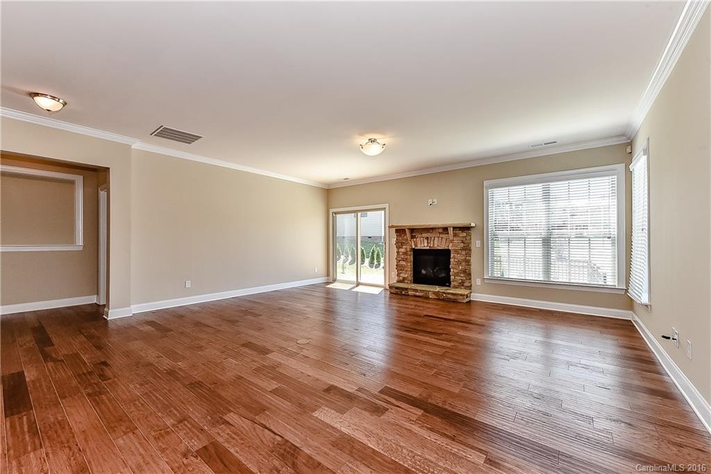 604 Brookhaven Drive, Unit HKC 95 Fort Mill, SC 29708 - Photo 10 of 24 an empty room with wooden floor fireplace and windows