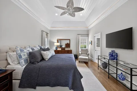 a bedroom with a bed couch and windows