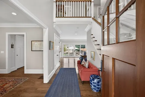 a open kitchen with stainless steel appliances granite countertop a sink a stove a dining table and chairs with wooden floor