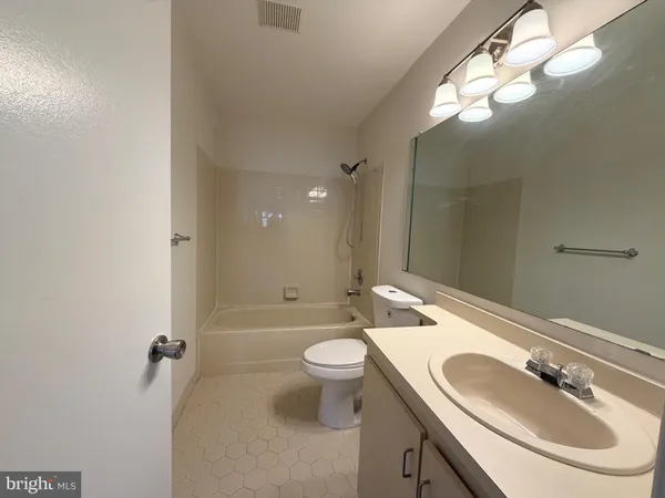 a bathroom with a sink a toilet a mirror and shower