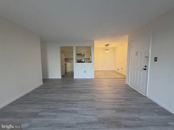 a view of a kitchen with wooden floor and a refrigerator