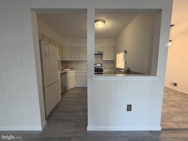 a kitchen with cabinets and wooden floor