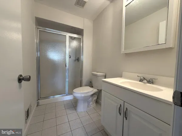 a bathroom with a granite countertop sink mirror vanity and toilet