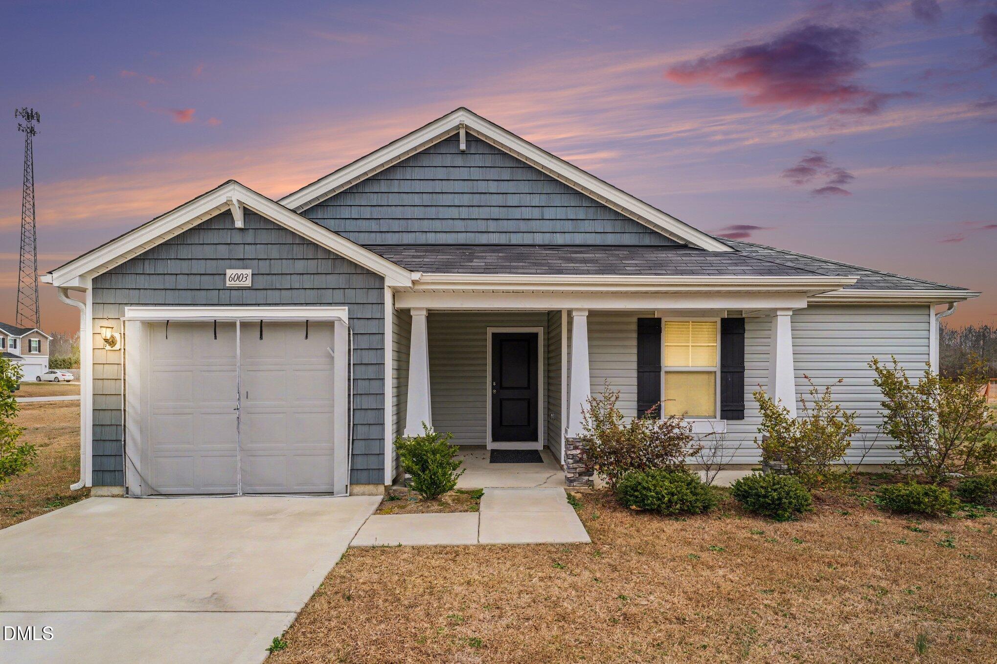 6003 Lowgrass Road Stedman, NC 28391 - Photo 1 of 24 a front view of a house with a garden