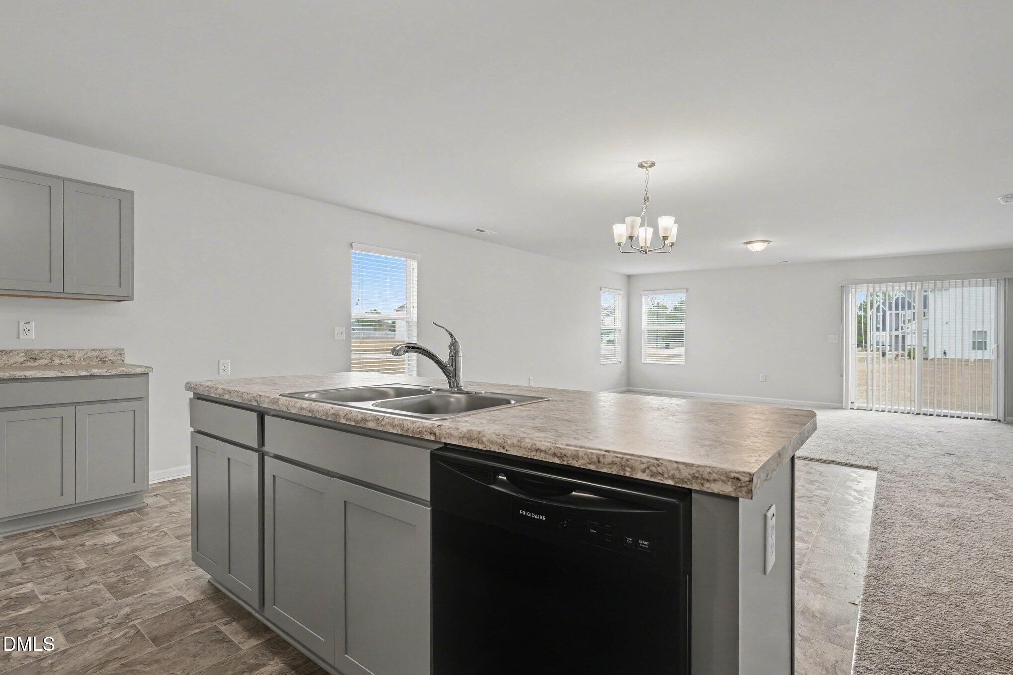 6003 Lowgrass Road Stedman, NC 28391 - Photo 4 of 24 a kitchen with a granite countertop sink stove and cabinets