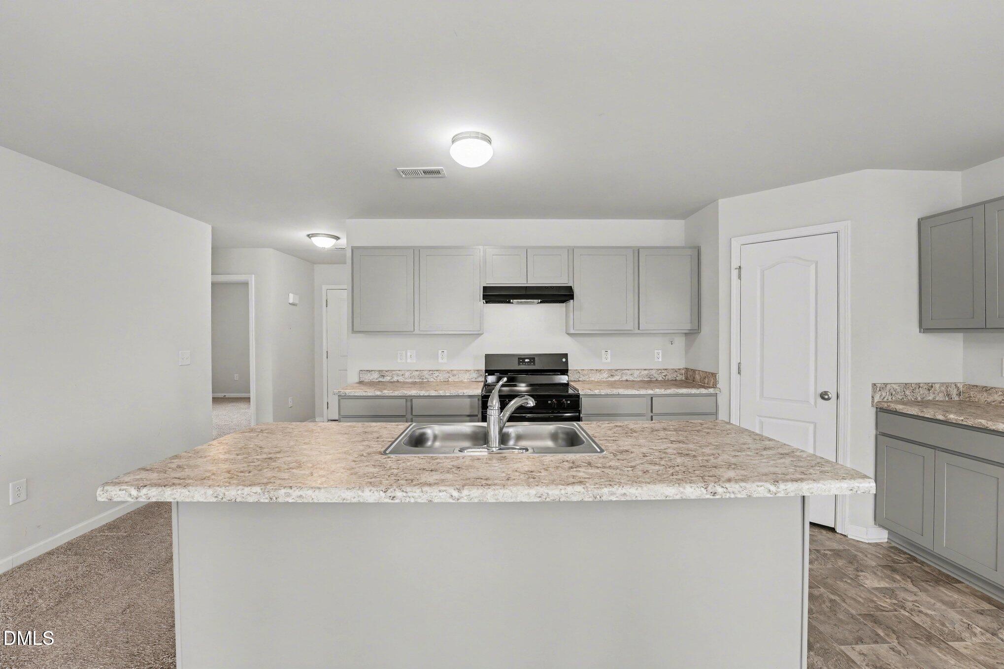 6003 Lowgrass Road Stedman, NC 28391 - Photo 5 of 24 a kitchen with kitchen island a sink stove and refrigerator