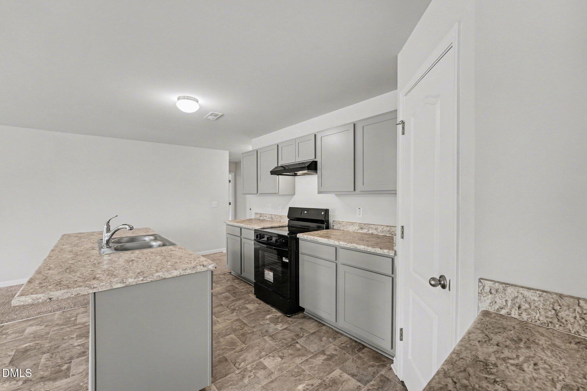 6003 Lowgrass Road Stedman, NC 28391 - Photo 6 of 24 a kitchen with stainless steel appliances granite countertop a sink stove and refrigerator