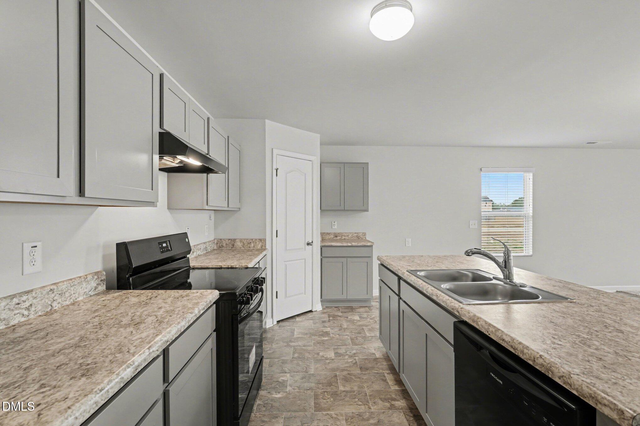 6003 Lowgrass Road Stedman, NC 28391 - Photo 7 of 24 a kitchen with a sink stove and refrigerator