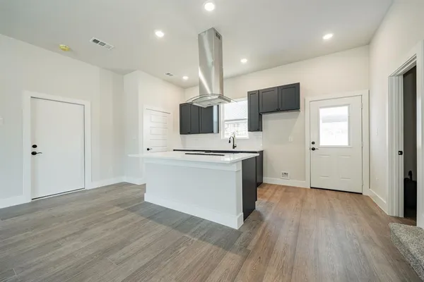 a kitchen with kitchen island stainless steel appliances a sink and a stove