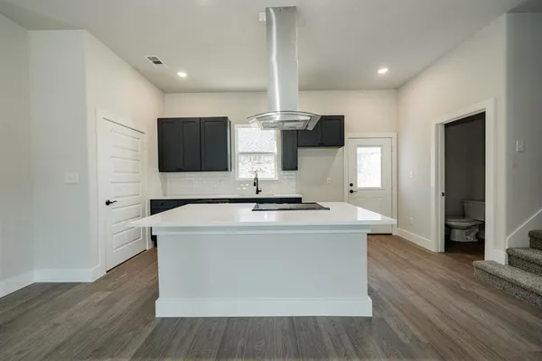 a kitchen with stainless steel appliances kitchen island granite countertop a sink and a stove top oven
