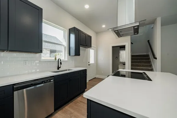 a kitchen with stainless steel appliances granite countertop a sink and a stove