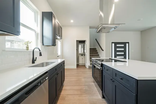 a view of a kitchen with a stove wooden floor and window
