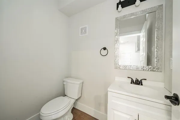 an empty room with wooden floor ceiling fan and windows