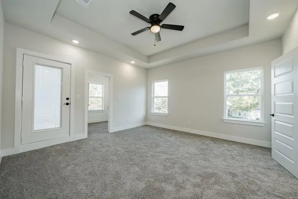 en empty room with windows and ceiling fan