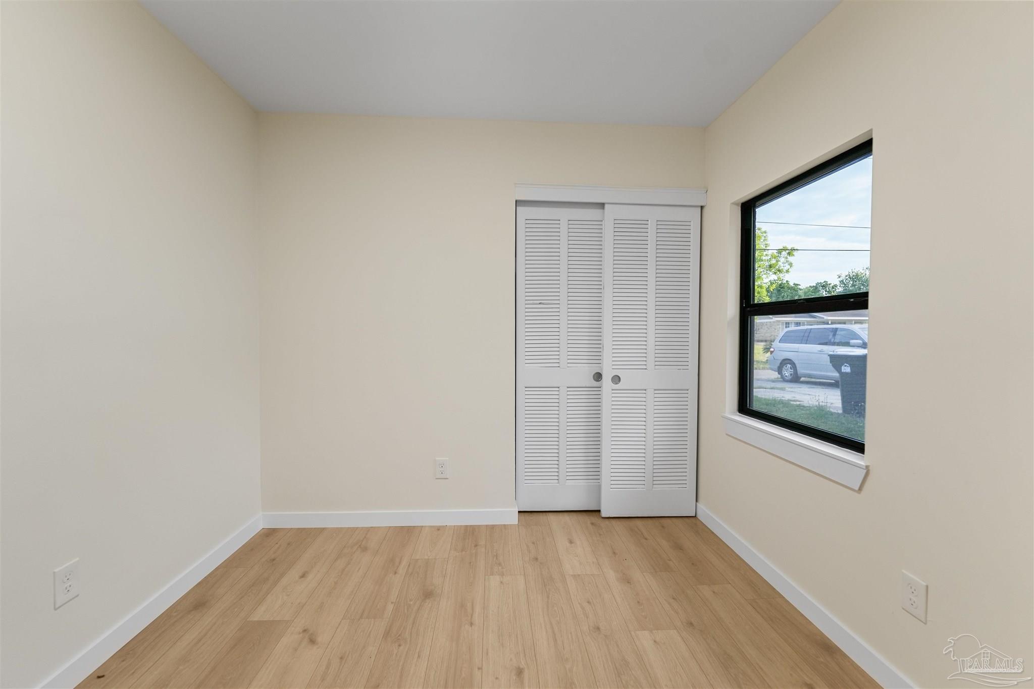 842 Belair Road Pensacola, FL 32505 - Photo 13 of 20 a view of an empty room with window and wooden floor