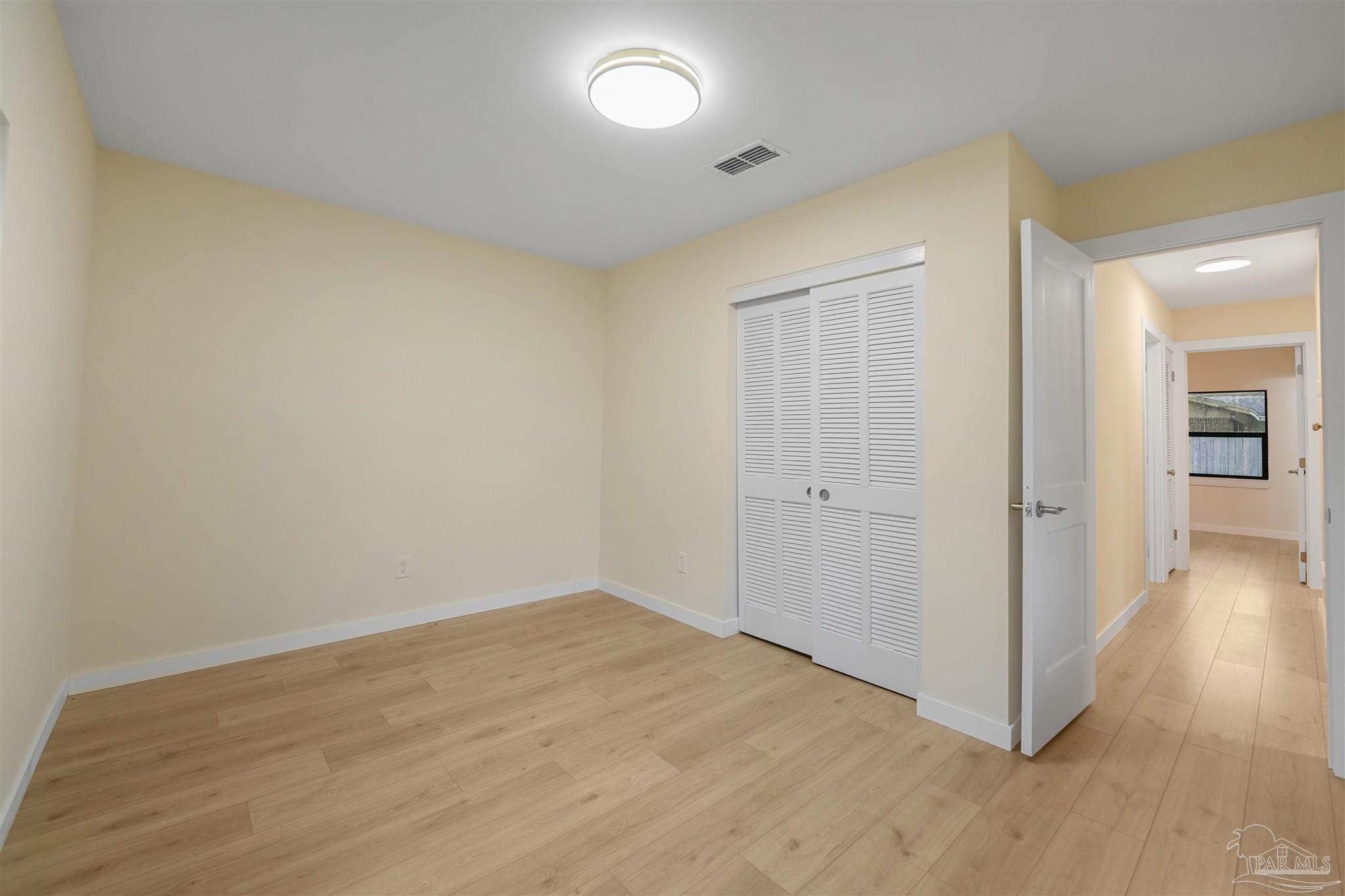 842 Belair Road Pensacola, FL 32505 - Photo 15 of 20 an empty room with wooden floor and windows