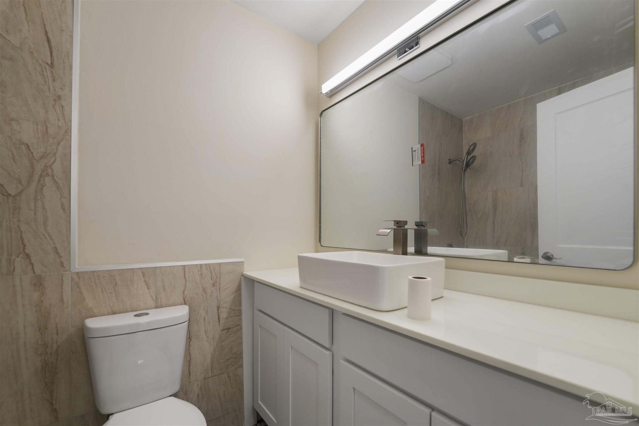 842 Belair Road Pensacola, FL 32505 - Photo 17 of 20 a bathroom with a toilet a sink and mirror