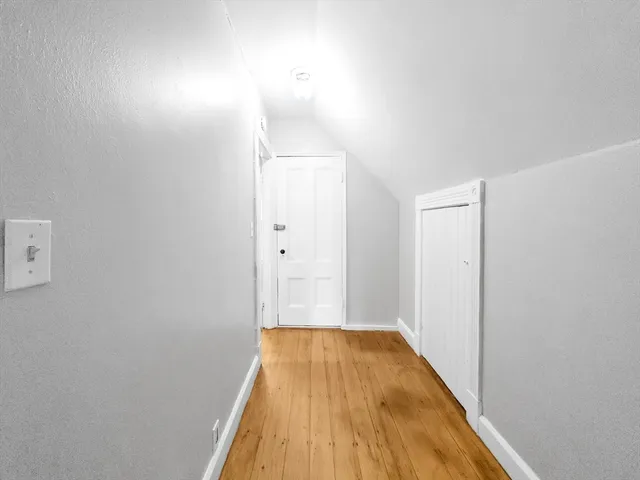 a view of a room with wooden floor and a ceiling fan