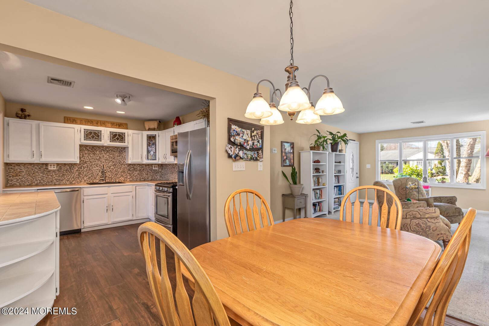 4 Cherry Tree Lane Middletown, NJ 07748 - Photo 6 of 31 a large white kitchen with a refrigerator a sink dishwasher a dining table and chairs with wooden floor