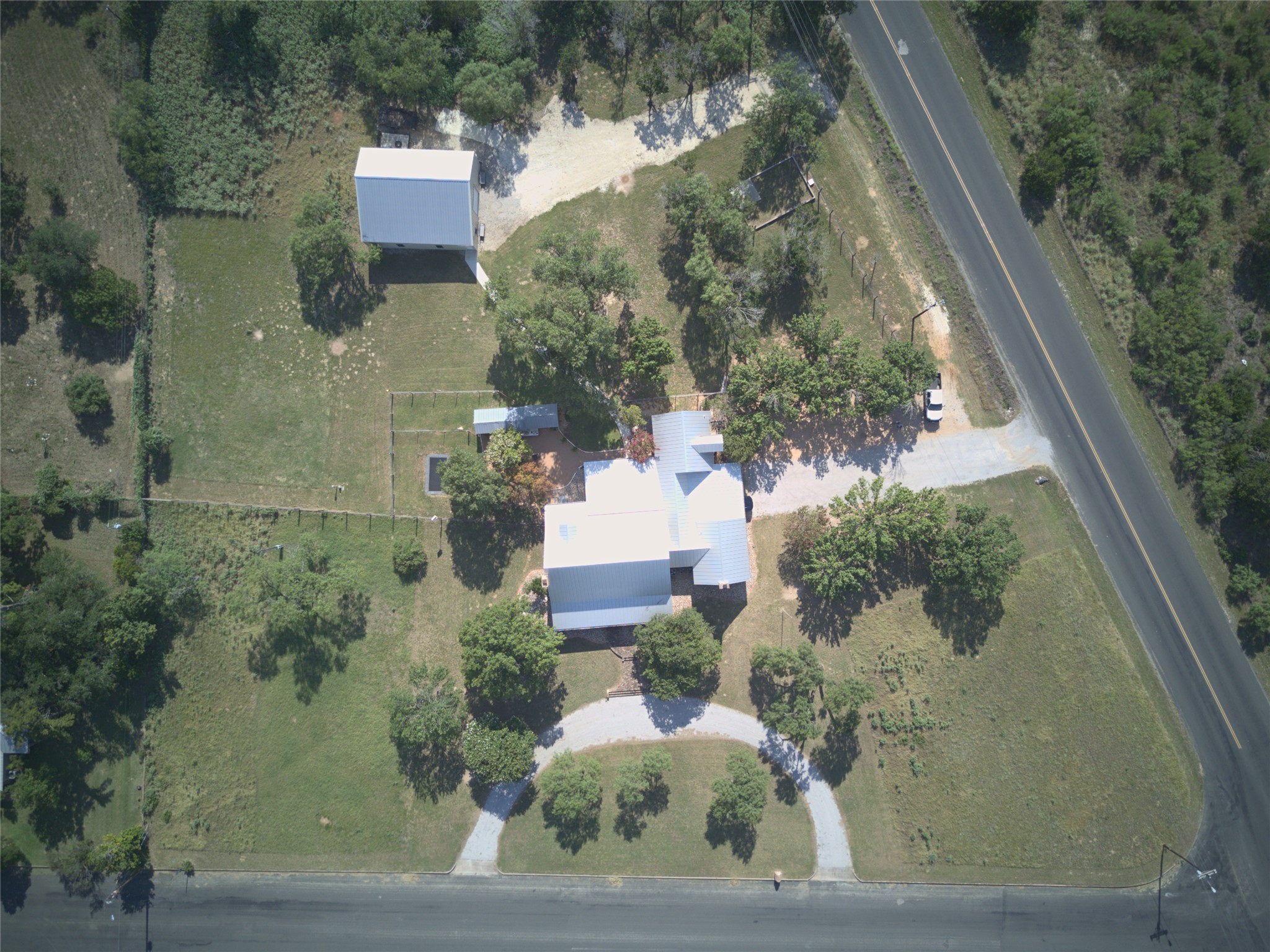 405 Frederick Road Fredericksburg, TX 78624 - Photo 29 of 29 An aerial perspective reveals a well-maintained property with ample land, diverse structures, and convenient road access.