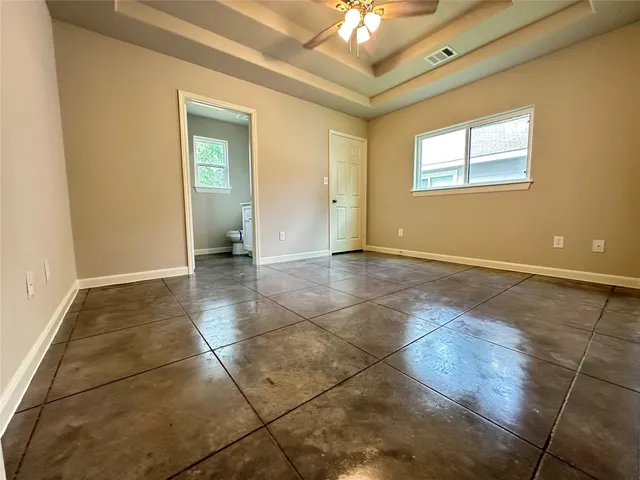 a view of an empty room with a chandelier fan
