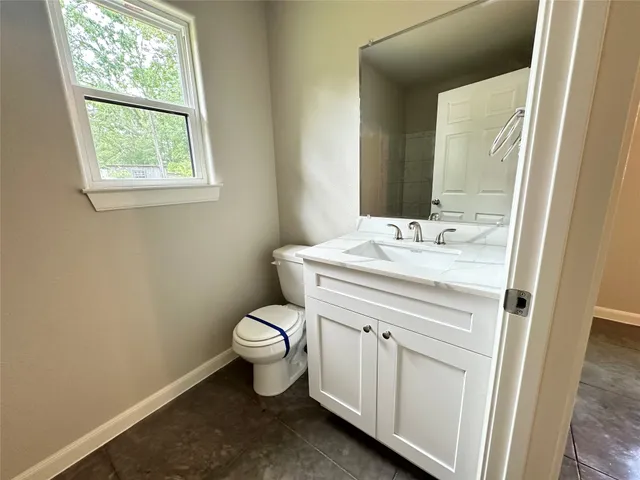 a bathroom with a sink toilet and window