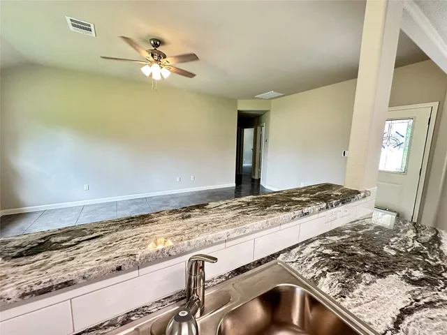 a view of a kitchen island a sink wooden floor and a window