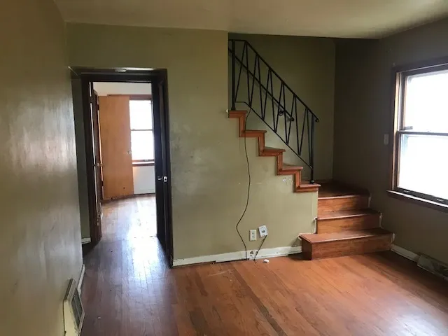 a view of entryway and hall with wooden floor