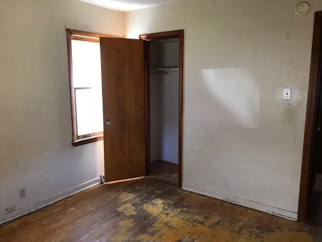 an empty room with windows and closet