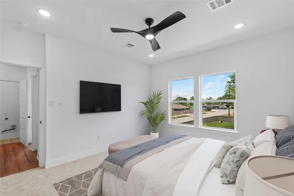 an empty room with windows and ceiling fan