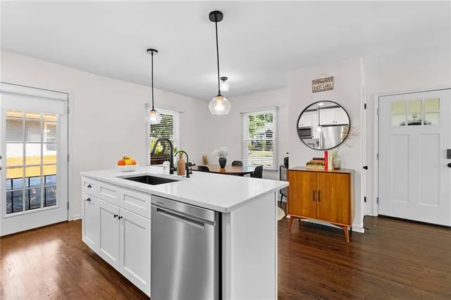 a view of a kitchen sink and wooden floor