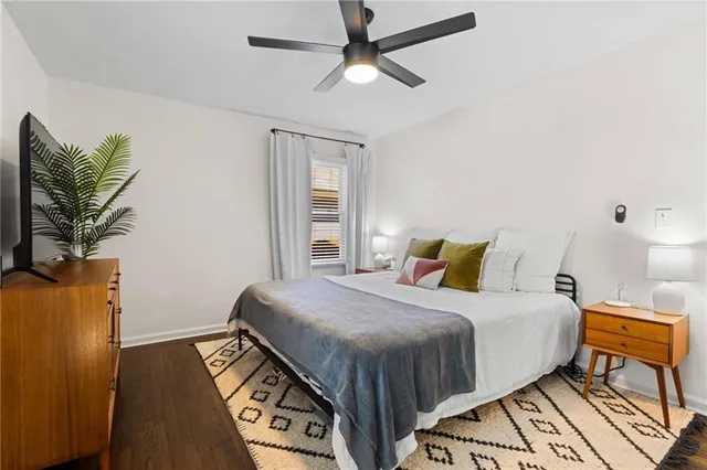 a bedroom with a bed lamps and wooden floor
