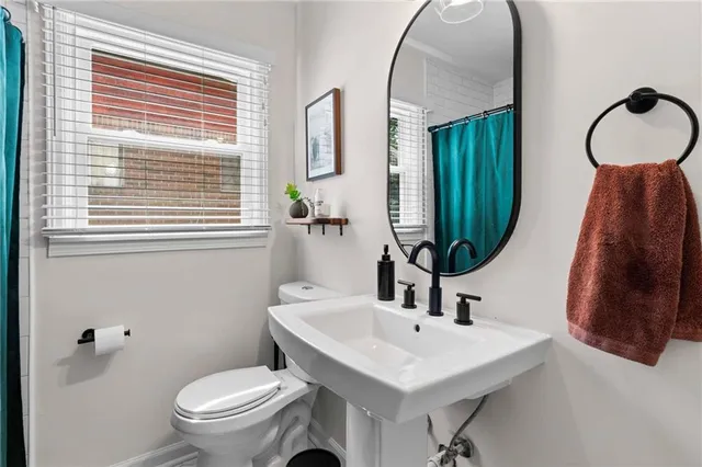 a bathroom with a toilet a sink and a mirror