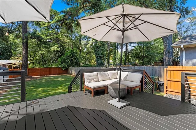 a view of backyard with deck and a large tree