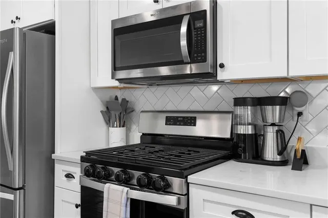 a kitchen with stainless steel appliances granite countertop a stove and a microwave