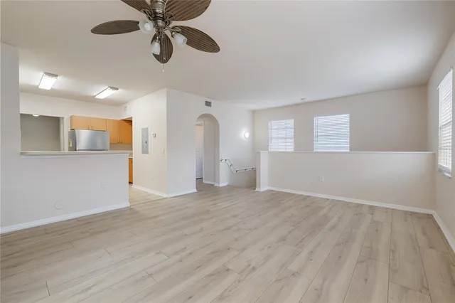 a view of an empty room with window and wooden floor