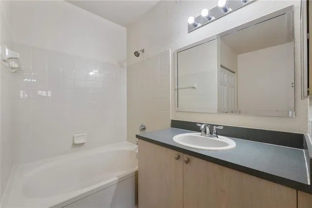 a bathroom with a sink a mirror and a bathtub