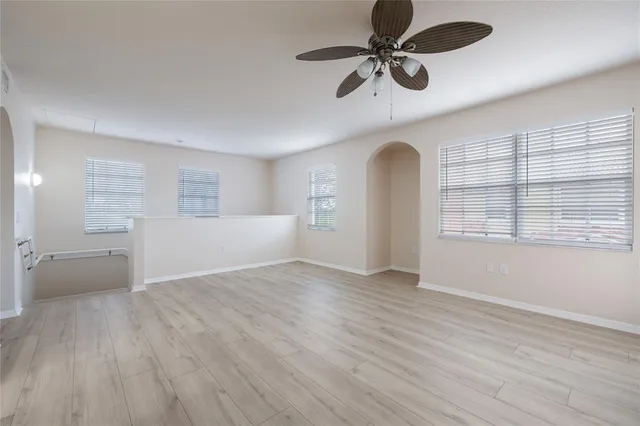 a view of an empty room with a window and wooden floor