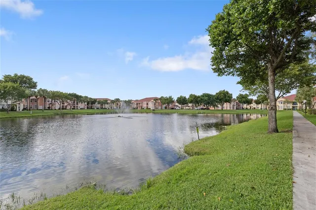 a front view of a house with a garden and lake view