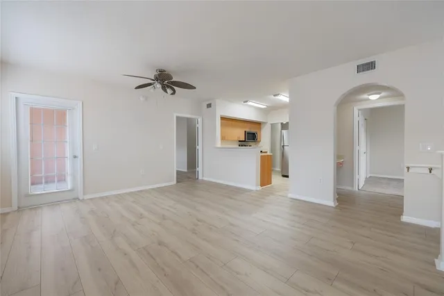 a view of a big room with wooden floor and a kitchen