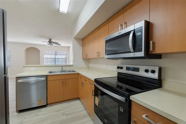 a kitchen with stainless steel appliances a stove microwave and sink