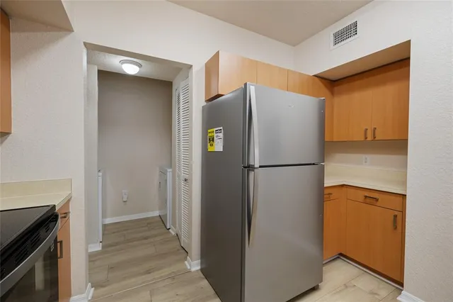 a view of a kitchen with a refrigerator and a sink