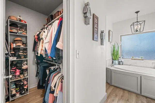 a view of walk in closet with clothes and shoes