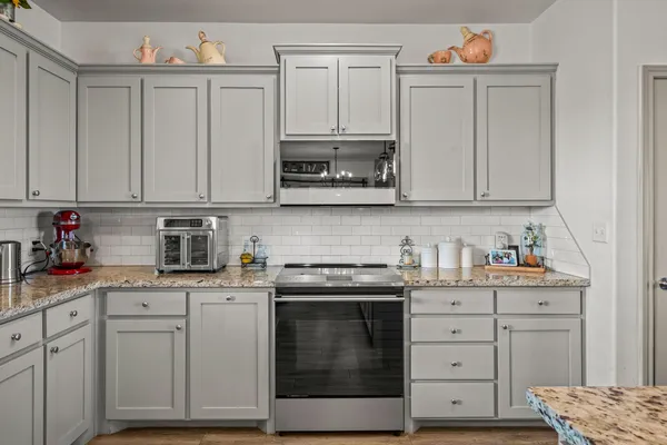 a kitchen with cabinets appliances and a wooden floor
