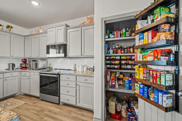 a open kitchen with stainless steel appliances cabinets and a book shelf