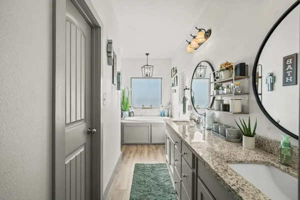 a large bathroom with a granite countertop double vanity sink a mirror and vanity