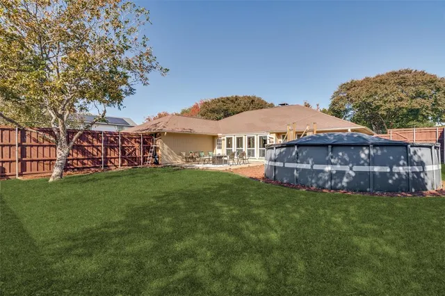 a view of a house with a big yard and large trees