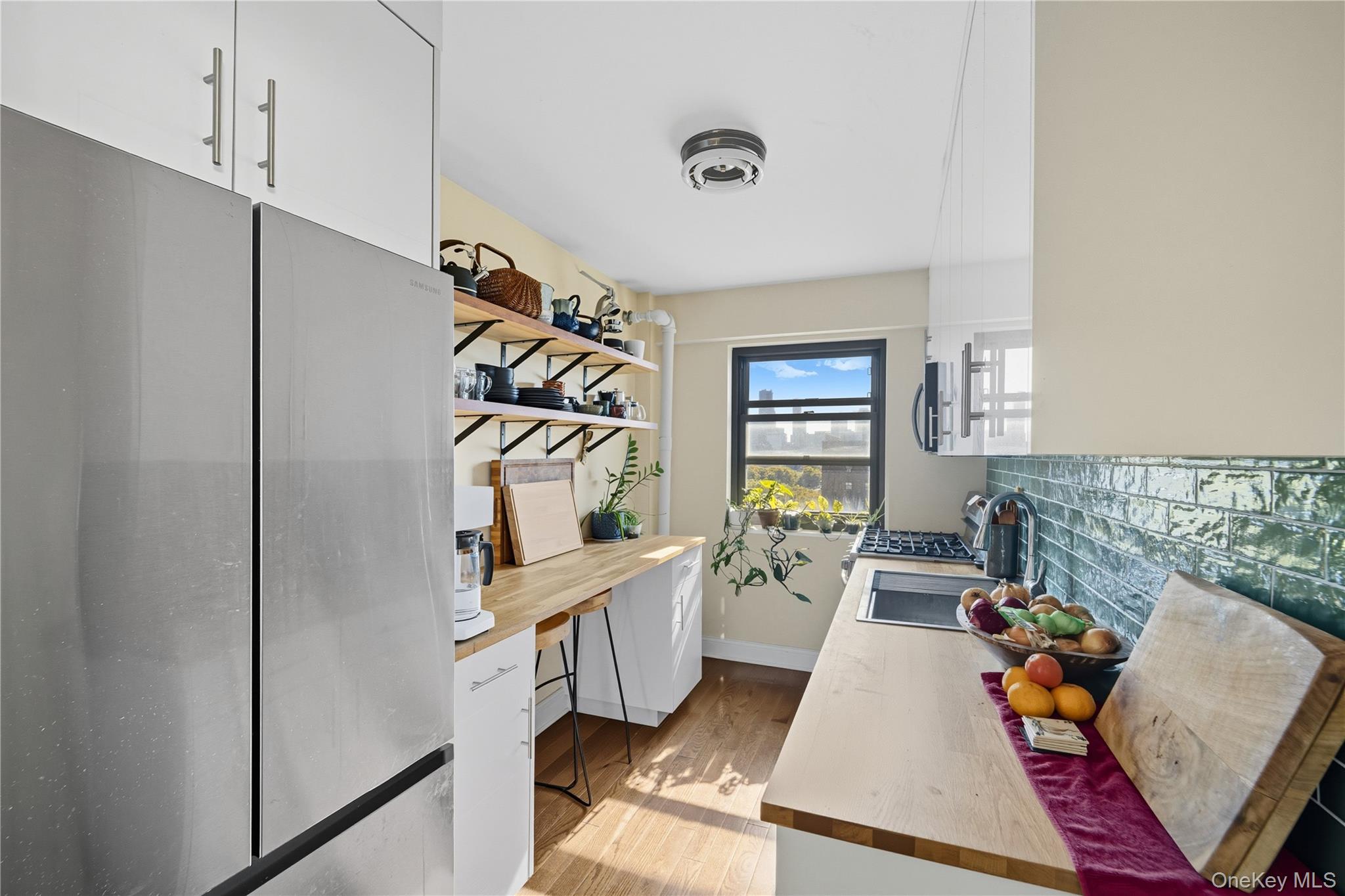 21-20 33rd Road, Unit 15C Queens, NY 11106 - Photo 6 of 18 a living room with furniture and a window
